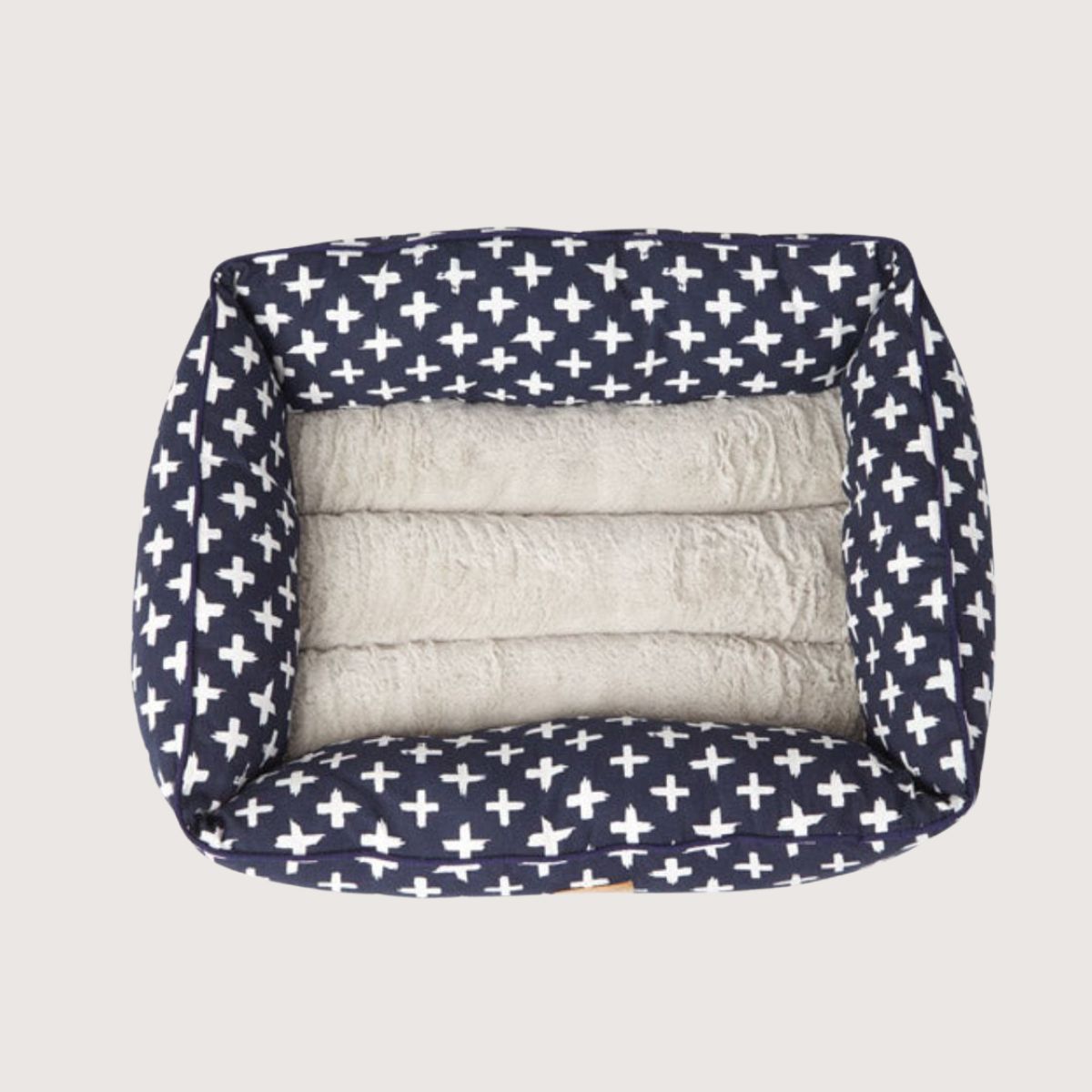 Navy blue pet bed with white cross pattern and gray interior on a white background