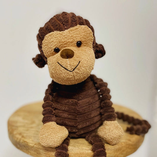 Stuffed dog toy on a wooden base with a white background