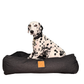 Dalmatian dog sitting on a black denim pet bed with a visible brand logo.