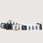 Adjustable hemp cat collar with charcoal gray stripes, a brass bell fitting, and a black buckle.