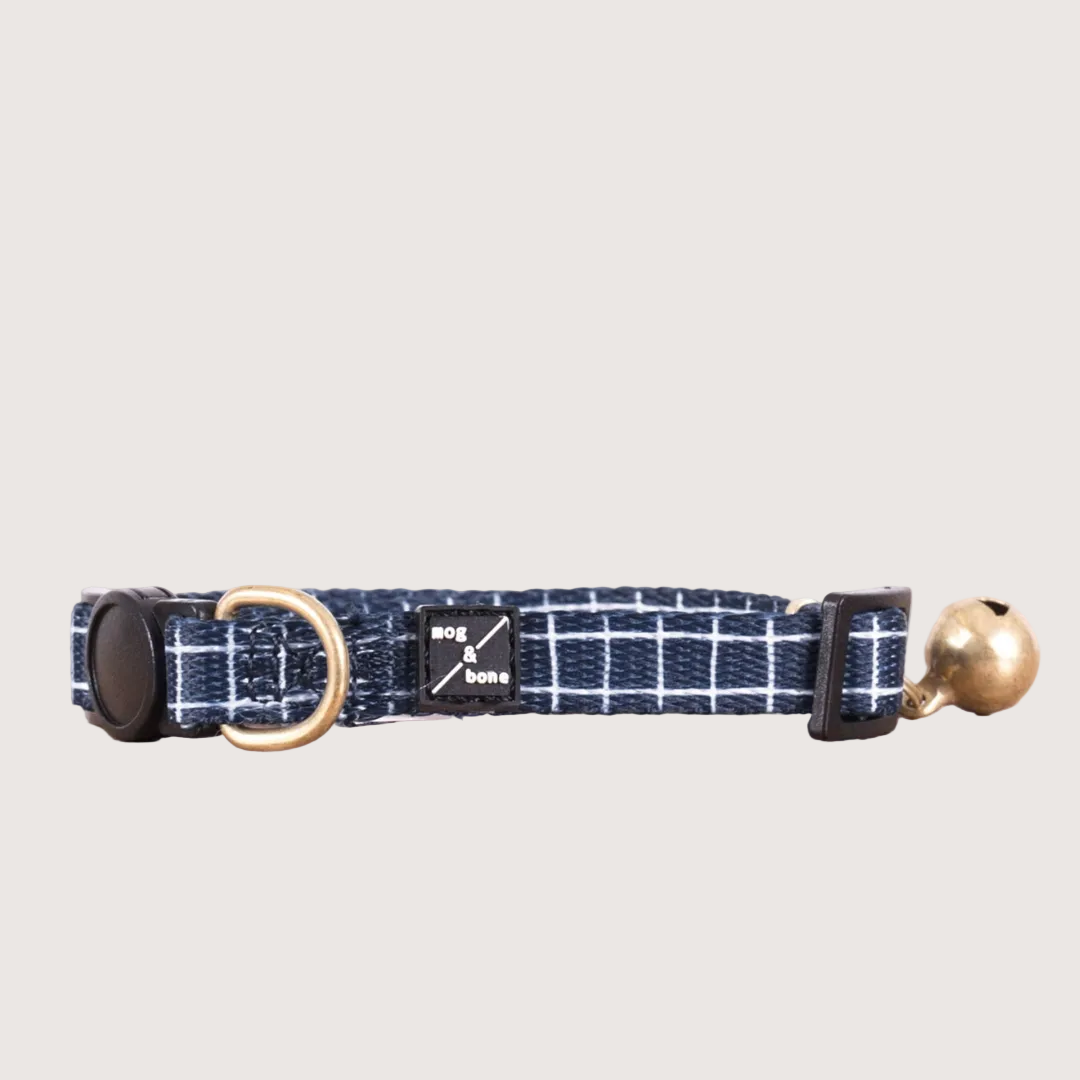 Adjustable navy neoprene cat collar with a brass bell and checkered pattern