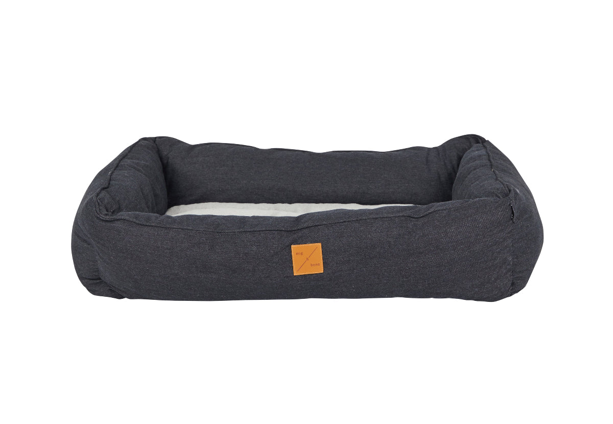black denim pet bed with a small brown tag on a white background