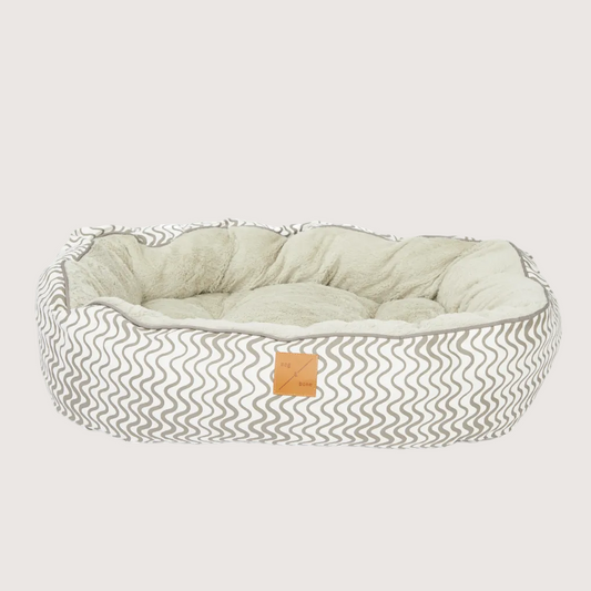 Pet bed with wavy pattern and beige cushion on a white background