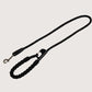 Black dog leash with a metal clip on a white background